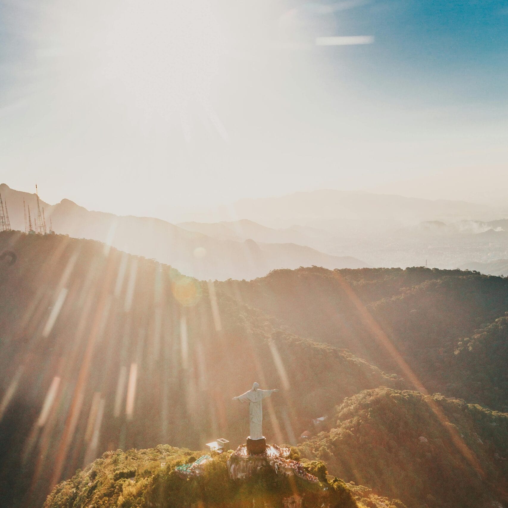 Breathtaking aerial photograph of Christ the Redeemer with sun rays over Rio de Janeiro, Brazil.