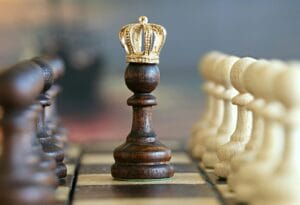 A brown pawn with a crown stands prominently on a chessboard, symbolizing strategic play.